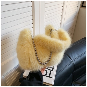 Détail de la texture en fausse fourrure jaune clair et de la chaîne à billes argentée