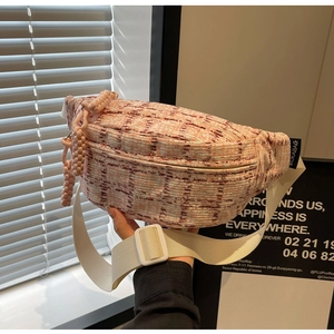Detailed view of pink tweed texture and decorative rope zipper puller on the crossbody bag