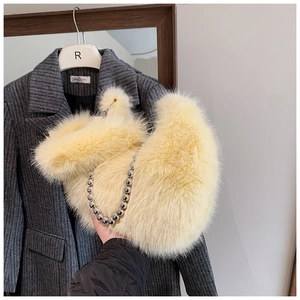 Gros plan sur un sac seau en fausse fourrure jaune avec bandoulière chaîne à billes
