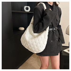 Detailed view of white quilted puff tote bag with soft shell-like texture and large capacity