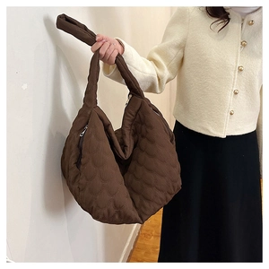 Detail of dark brown quilted canvas tote bag with unique 3D wave texture and side zipper