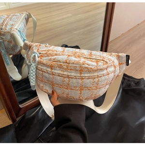 Detailed view of large tweed crossbody bag with blue plaid texture and wide strap