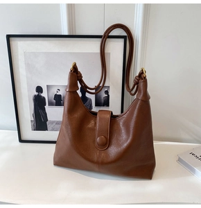 Detail view of brown faux leather hobo bag with litchi texture and knotted strap