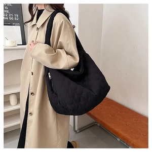 Detailed view of black quilted hobo bag with unique fish scale pattern on shoulder bag