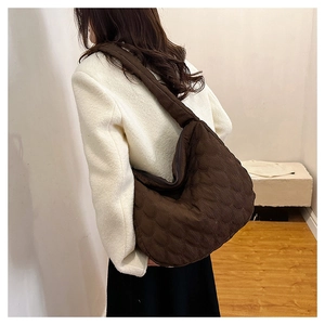Detail view of large brown quilted crescent hobo bag with textured fabric surface