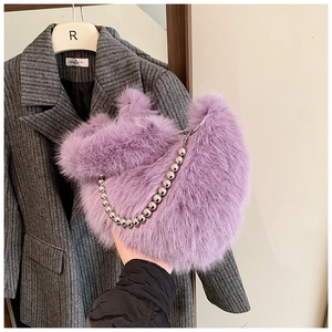 Gros plan du sac seau en fausse fourrure violette avec une bandoulière chaîne argentée