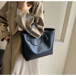 Gros plan du sac cabas en cuir noir avec surpiqûres contrastées et logo minimaliste