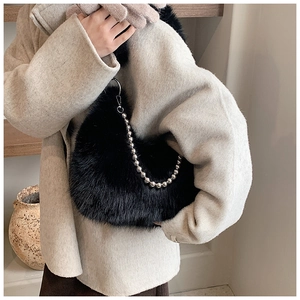 Détail d'un sac d'épaule en fausse fourrure noire avec bandoulière à billes argentées