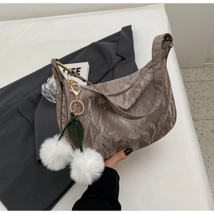 Détail du sac à texture marbrée avec breloque en peluche et ferrures dorées