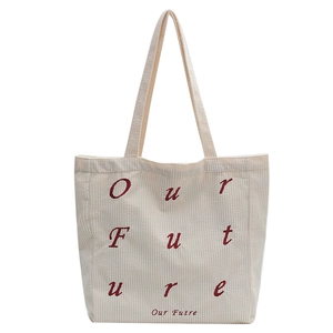 Minimalist cream corduroy tote bag with red Our Future lettering for daily commute