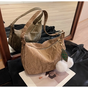 Détail du sac hobo plissé marron avec breloque en peluche et boucle dorée