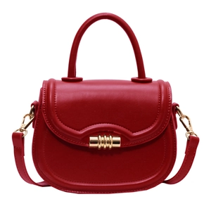 Elegant red saddle handbag with gold spiral lock and detachable strap on white background