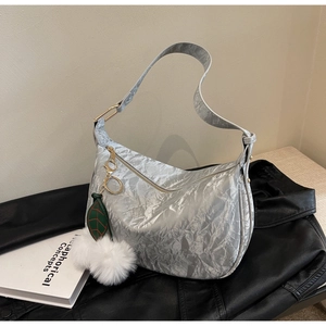 Détail du sac hobo argenté métallisé avec texture froissée et breloque pompon doux