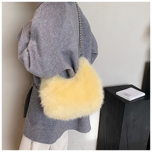 Détail d'un sac à main en peluche jaune avec une élégante bandoulière en chaîne argentée
