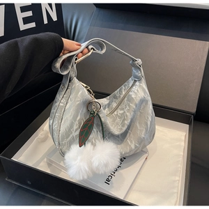Détail du sac hobo marbré gris avec breloque en peluche dans un coffret cadeau