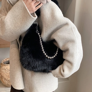 Plush black faux fur crossbody bag with a stylish silver bead chain strap shown on model