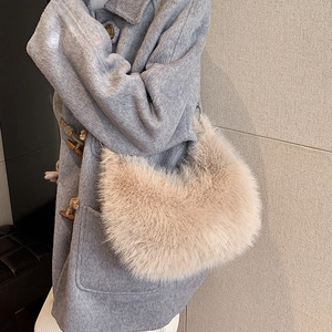 Sac hobo en fausse fourrure beige pour l'hiver, porté avec un manteau gris chic