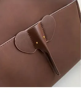 Close-up of elephant leather patch with gold bead eyes on matte tote bag