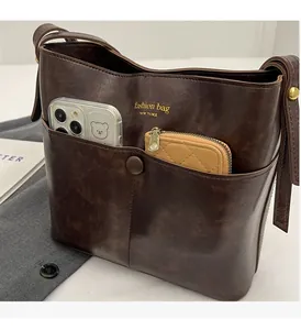 Detail of retro brown bucket bag showing spacious interior with phone and wallet
