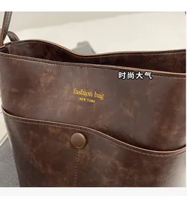 Close-up of brown bucket bag showing fashion bag New York text and magnetic snap