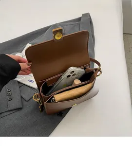 Interior view of vintage brown leather crossbody bag showing spacious capacity and phone