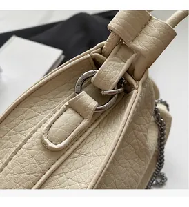 Close-up of premium lychee texture leather and silver metal chain hardware on bucket bag