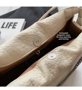 Close-up of cream leather bucket bag showing hidden magnetic buckle and inner pocket