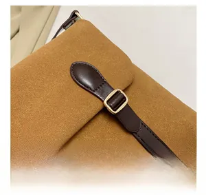 Detail of vintage brown suede tote bag featuring contrast leather straps and gold buckle