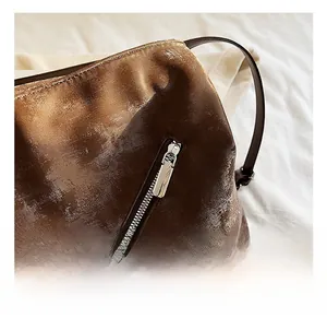 Detailed macro view of high-quality silver metal zipper on vintage brown tote bag