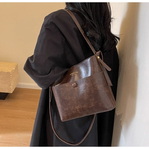Detail view of dark brown vintage leather bucket bag with gold NEW YORK embossed lettering