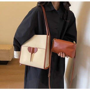 Detail shot of the ivory and brown tote bag with elephant ear decor on a model