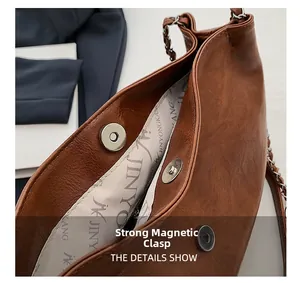 Detail view of strong magnetic buckle on brown leather tote bag with branded lining