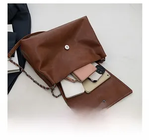 Detail of spacious brown retro tote bag interior with magnetic clasp and chain strap