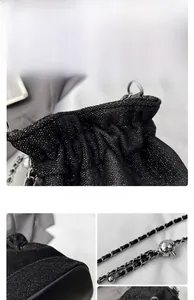 Detail of black glitter bucket bag with silver chain strap and spherical charm
