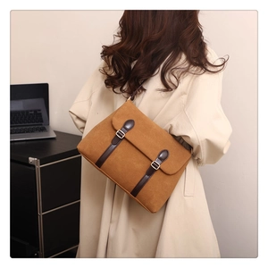 Back view of model wearing a vintage brown suede tote bag with leather strap detailing