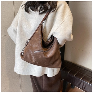 Detail of dark brown vintage faux leather tote with silver zippers and wide strap