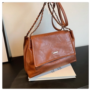 Detailed macro view of caramel brown vintage PU leather texture with metal chain strap