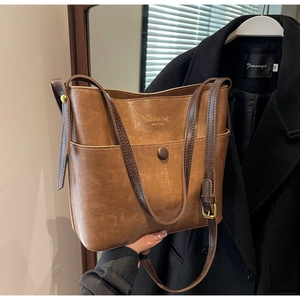 Detail view of brown vintage bucket bag with textured faux leather and snap pocket