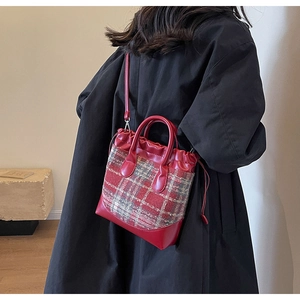 Détail du sac seau à carreaux rouges avec garniture en similicuir et cordon de serrage