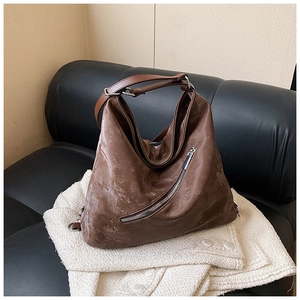 Close-up of vintage brown oil wax leather tote featuring unique diagonal metal zipper