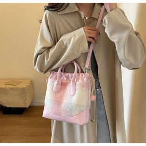 Détail du sac seau en tweed à carreaux roses avec cordon et patchwork en cuir