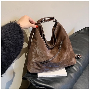 Detail of dark brown vintage tote bag with decorative zipper and textured finish
