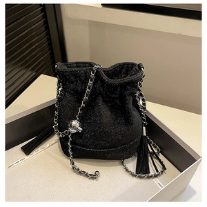 Detail of glittery black bucket bag with chain strap and sphere charm in gift box