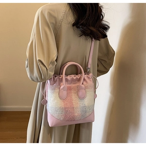 Sac seau à carreaux peluche rose avec cordon de serrage porté par un mannequin