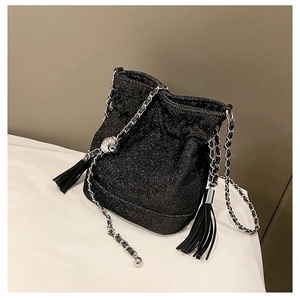 Close-up of glitter bucket bag with silver chain strap and leather tassel details