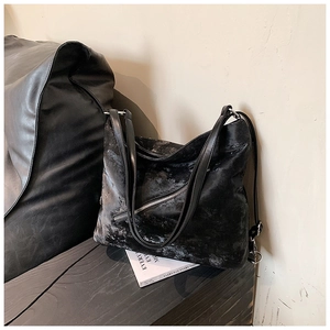 Close-up of black tote bag with vintage matte texture and diagonal zipper details