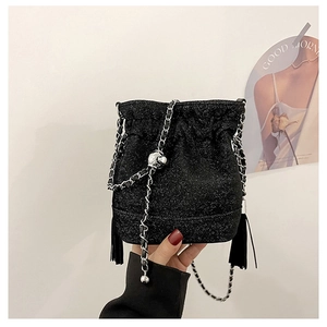 Detailed view of black shimmer bucket bag with fringe tassels and gold ball chain