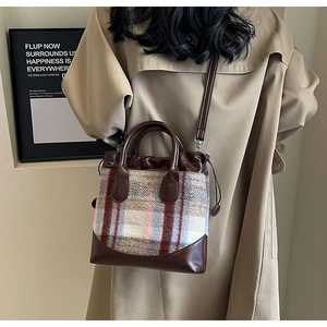 Détail du sac seau à carreaux vintage avec poignées en cuir et bandoulière réglable