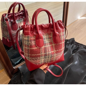 Détail du sac seau en tweed rouge montrant la fermeture à cordon et les doubles poignées