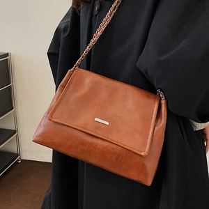 Retro caramel brown leather tote bag with chain strap and silver metal buckle detail